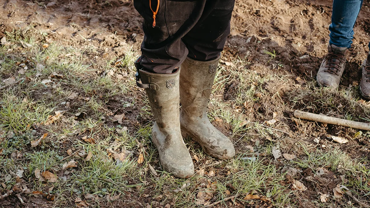 A pair of wellies being worn in a field